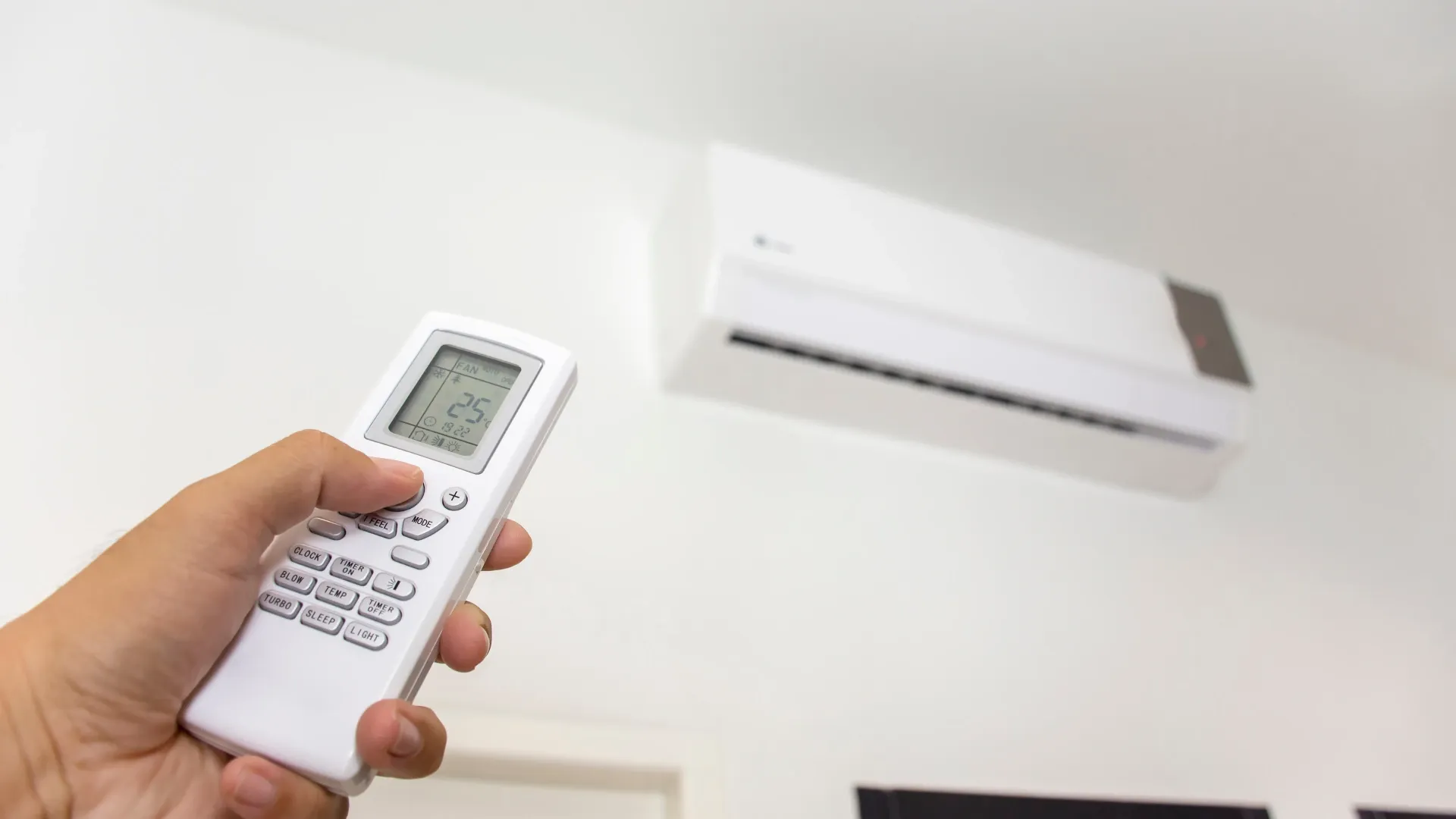 Ar-condicionado split instalado em ambiente residencial sendo ajustado por controle